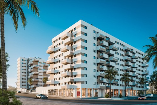 Fachada exterior del edificio Insur Elyonia en Entrenúcleos. Diseño de vanguardia que combina volúmenes blancos y arena, amplios ventanales y locales comerciales, integrado en un entorno urbano moderno.